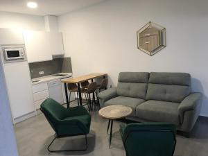 a living room with a couch and a table and a kitchen at Apartamentos Ad Theatrum in Merida