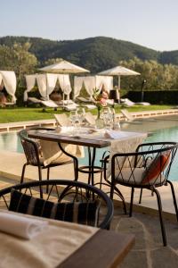 a patio area with chairs, tables, chairs and umbrellas at Borgo I Vicelli Country Relais in Bagno a Ripoli