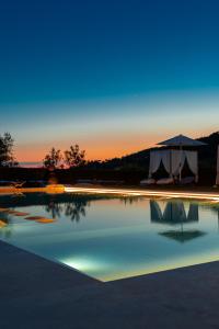 una grande piscina con tenda sullo sfondo di Borgo I Vicelli Adults Only Relais a Bagno a Ripoli