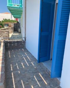 una puerta azul en el lateral de un edificio en VERANDA BLUE - POROS, en Poros