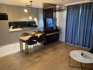 a kitchen and dining room with a table and chairs at EEE Apart Boutique in Constanţa