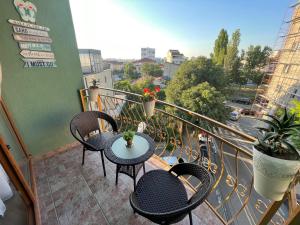 a balcony with tables and chairs and a view of a city at EEE Apart Boutique in Constanţa