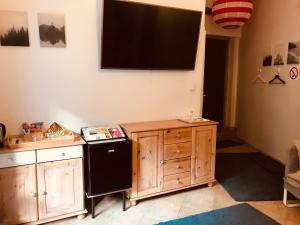 a kitchen with a black refrigerator and a tv on the wall at Apartament Starówka in Zielona Góra