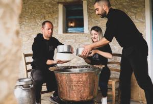a group of three people standing around a barrel at Domu Antiga in Gergei