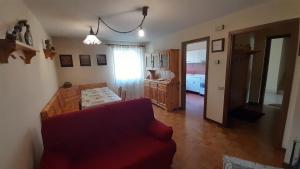 un soggiorno con divano rosso e una cucina di Appartamento Paolo a Lavarone