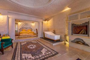 a bedroom with a bed and a tub in it at Helen Cave Suites in Goreme
