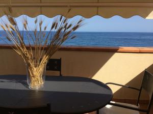 a glass vase sitting on a table with a view of the ocean at Casa Vacanze Samira in Fondachello