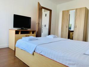 een slaapkamer met een groot bed en een televisie. bij Nosen Apartment in Bistriţa