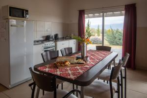 a kitchen with a dining table and a table and chairs at La Agustina Complejo Apart in Valle Grande