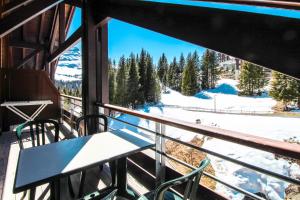 a view from the balcony of a ski lodge with a table and chairs at Two internally connecting 2-bed apartments with shared private entrance in Flaine