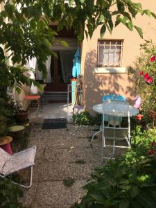 un patio con sillas y una mesa frente a una casa en Joli studio avec jardinet, en Aviñón