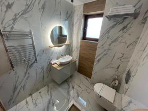 a bathroom with a sink and a toilet and a mirror at EEE Apart Boutique in Constanţa +78 photos