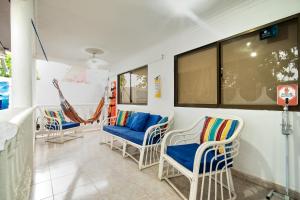 ein Zimmer mit Stühlen, einem Sofa und einem Fenster in der Unterkunft Hostal Palo Alto in San Andrés