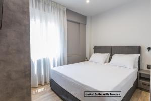 1 dormitorio con cama blanca y ventana en Athens Raise Acropolis Project en Athens