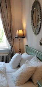 a bedroom with two beds with a lamp and a mirror at Hotell Örnen in Torsby