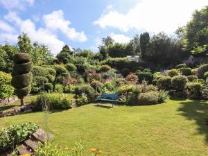 a blue bench sitting in the middle of a garden at The Poppy Fields Abode in Rhyl