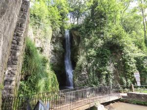 a waterfall next to a bridge next to a river at The Poppy Fields Abode in Rhyl