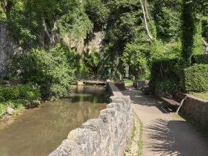 a stone wall next to a river with benches at The Poppy Fields Abode in Rhyl