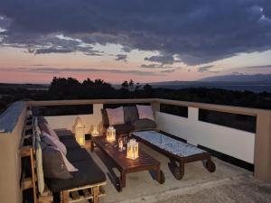 a patio with a couch and a table on a balcony at Apartmani Bellevue in Vir