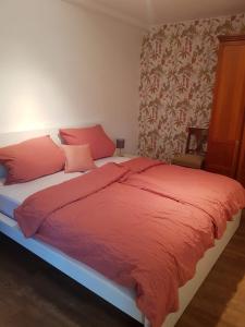 a bedroom with a bed with red blankets and pillows at Ferienhaus Anno 1903 in Weisenheim am Berg