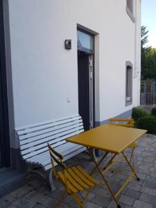 a yellow table and chairs next to a building at Ferienhaus Anno 1903 in Weisenheim am Berg