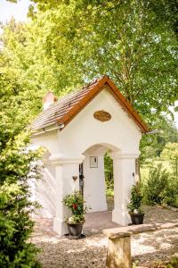 un petit bâtiment blanc avec deux plantes en pot dans l'établissement Siebler Übernachtungen am Bauernhof, à Wolnzach