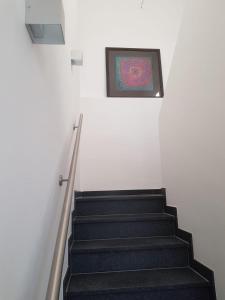 a staircase with a painting on the wall at Ferienhaus Anno 1903 in Weisenheim am Berg