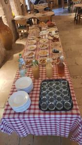 una mesa a cuadros roja y blanca con platos de comida en Masseria Parco di Castro en Montalbano