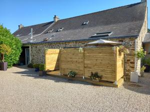 a wooden shed in front of a house at Aux Matins du Bonheur in Surzur