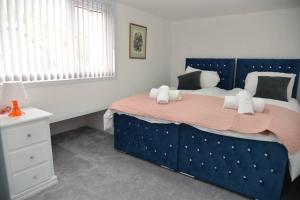 En eller flere senge i et værelse på Modern Stays - Hamilton House (8 Bedroom, Up to 14 beds, Free Parking)
