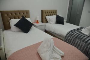 En eller flere senge i et værelse på Modern Stays - Hamilton House (8 Bedroom, Up to 14 beds, Free Parking)