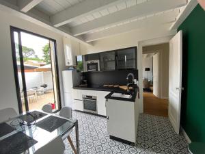 a kitchen with a stove and a green wall at Villa du bassin -un petit coin de paradis in Andernos-les-Bains