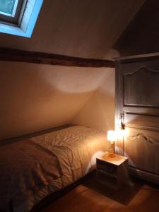ein Schlafzimmer mit einem Bett und einer Lampe auf einem Tisch in der Unterkunft La grange Loudervielle Louron Pyrénées in Loudenvielle