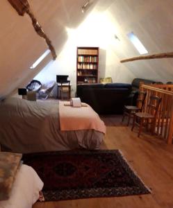 a bedroom with a bed and a couch in a attic at La grange Loudervielle Louron Pyrénées in Loudenvielle