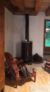 a living room with a fireplace and a chair at La grange Loudervielle Louron Pyrénées in Loudenvielle