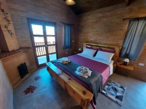 a bedroom with a bed in a room with windows at Chalés Santa Luzia in Santo Antônio do Pinhal