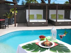 uma mesa com um prato de comida ao lado de uma piscina em Agua Viva by Umbral em Albufeira