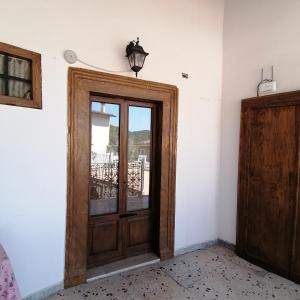 a wooden door in a room with a window at Piazzetta Del Forno - Monolocale in Assergi