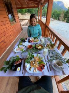 斑博納的住宿－Bujtina Malaj，坐在餐桌旁的女孩,配上食物盘