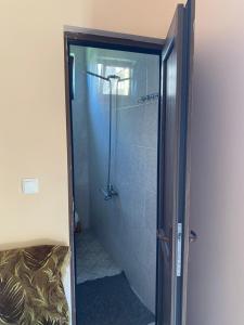 W łazience znajduje się prysznic ze szklanymi drzwiami. w obiekcie House Nature Sea w mieście Machindżauri