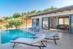 a swimming pool with two lounge chairs and a house at Messinian Riviera Villas in Petalidhion