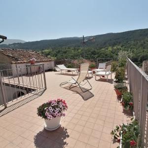 a patio with chairs and flowers on a balcony at Piazzetta Del Forno - Monolocale in Assergi