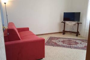 uma sala de estar com um sofá vermelho e uma televisão em CasaGiorgio a due passi dal centro storico em Florença