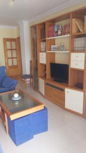a living room with a table and a tv at Apartamento Medina in Morche