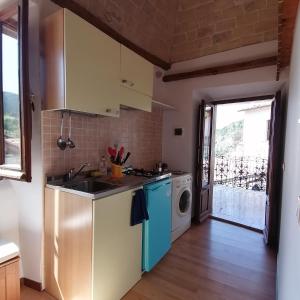 a kitchen with a sink and a washing machine at Piazzetta Del Forno - Monolocale in Assergi