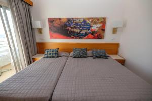 a bedroom with a large bed with two pillows at Tylos Beach Hotel in Kato Pyrgos