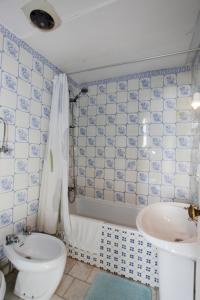 a blue and white bathroom with a toilet and a sink at Casa Grande Portugal in Burgau