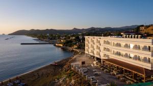 a building on the shore of a body of water at Tylos Beach Hotel in Kato Pyrgos