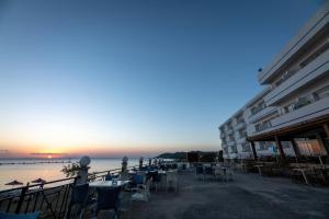 a group of tables and chairs next to the ocean at Tylos Beach Hotel in Kato Pyrgos
