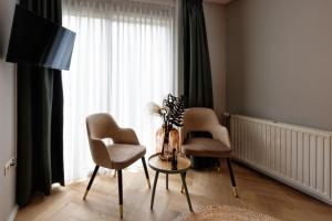 a living room with two chairs and a table and a window at Hotel Karsten in Norg